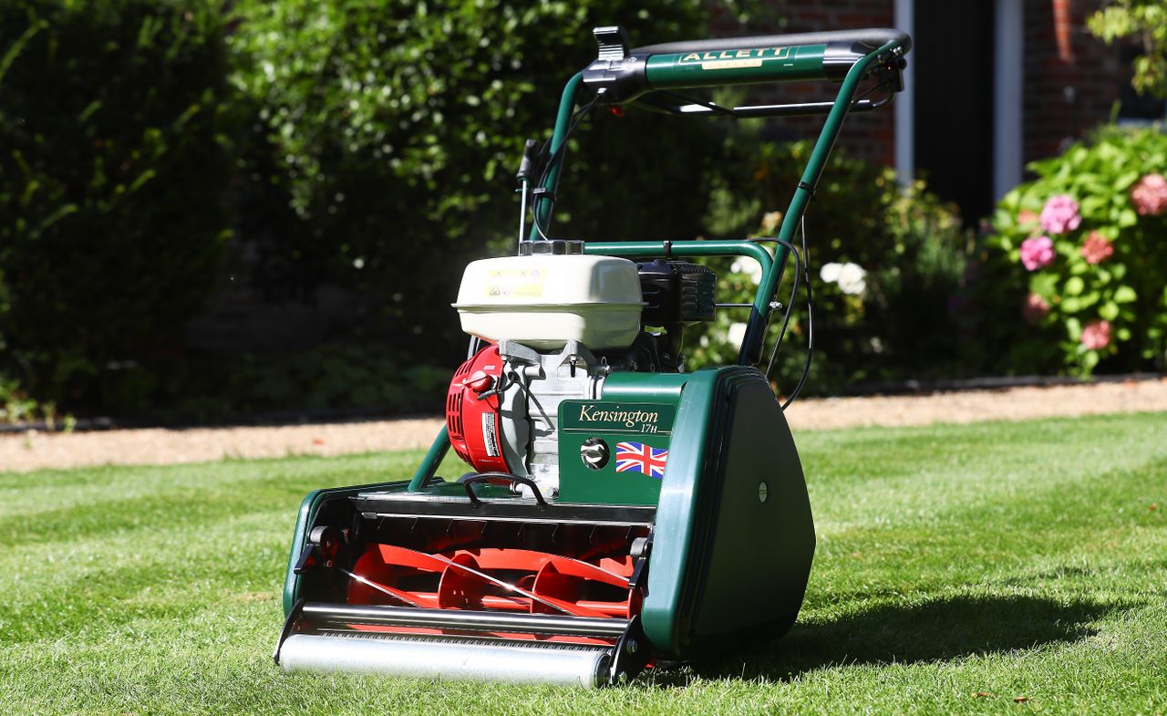 Premium Allett Kensington lawnmower on a well-manicured garden lawn in summer sunlight.